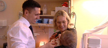 Dr. Max Menton streichelt intensivpflegebed&uuml;rftiges Kind