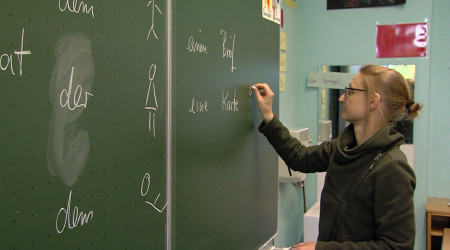Lehrerin schreibt an der Tafel
